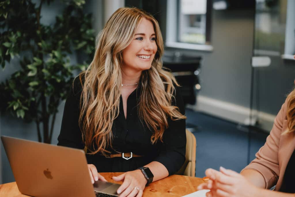 Anna Hutton, Director of Behaviour Change at MacMartin, smiling whilst working at her laptop.